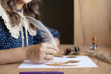 Woman Writing with Quill Pen on Paper in Rustic Setting