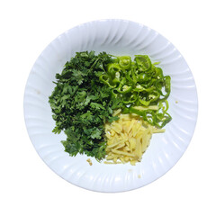 Chopped green chillies, coriander and ginger are placed on a plate