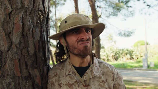 Rough Military Man Eats Energy Food And Spits Leaning Against A Tree