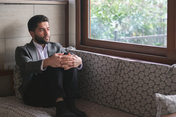 Thoughtful businessman sitting on the couch.