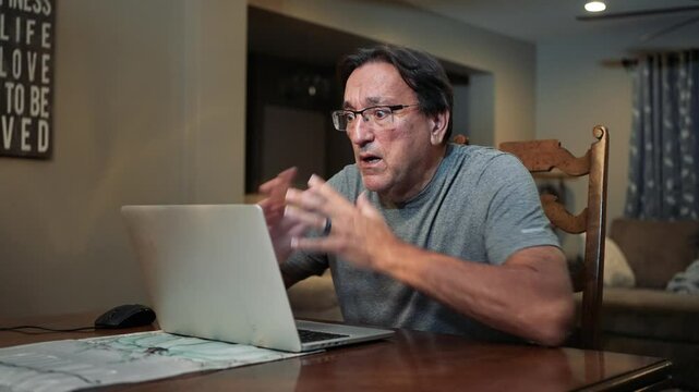 A man working at home uses his laptop to get bad news, perhaps in an email.  	