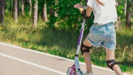 Child riding scooter. Active outdoor fun for kids. Summer sports for children.