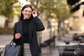 Beautiful woman in stylish suit outdoors. Space for text