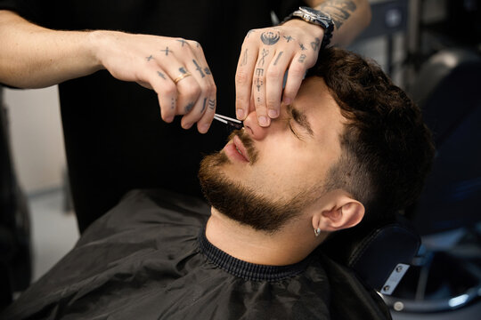 Groomer uses wax to tidy up client nasal hair