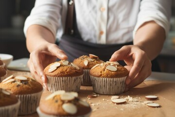 The Art of Baking: Close-up of a baker's hands carefully arranging freshly baked muffins, a delicate touch adding almond slices for a final flourish.