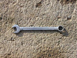 Horn and cap wrench made of metal on the background of a concrete surface in daylight. The tools are in the workshop. Cars and mechanics