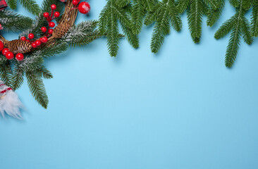 Spruce branches and Christmas toys on a blue background, top view