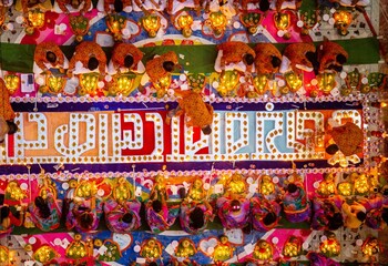 Fototapeta premium Bangladeshi Hindu devotees sit with candle light pray to God at Shri Shri Lokanath Brahmachari Ashram temple during the religious festival Kartik Brati. Thousands of Hindu devotees sits with candles.
