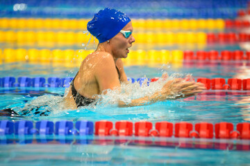 Swimmer girl swims breaststroke swimming style in the pool