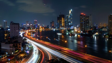 Fototapeta premium Nighttime Cityscape Overlooking River with Colorful Light Trails from Cars and Skyscrapers Illuminated by Urban Glow in a Vibrant Metropolis