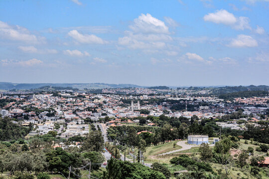 Scenic view of Vinhedo, S&atilde;o Paulo, showcasing urban and green landscapes with rolling hills and scattered buildings. Clear sky enhances the natural beauty of this Brazilian city.