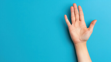 A womans hand displays a stop sign on a light blue backdrop, embodying a clear message of pause and reflection.