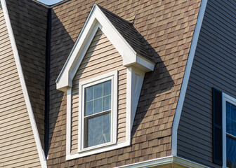 Obraz premium Dormer window and steep shingled roof of a family home in Brighton, Massachusetts, USA 