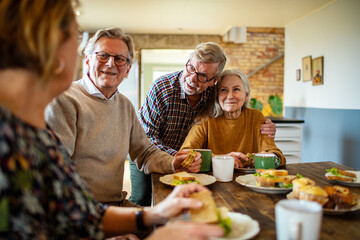 Group of senior friends enjoying breakfast together at home