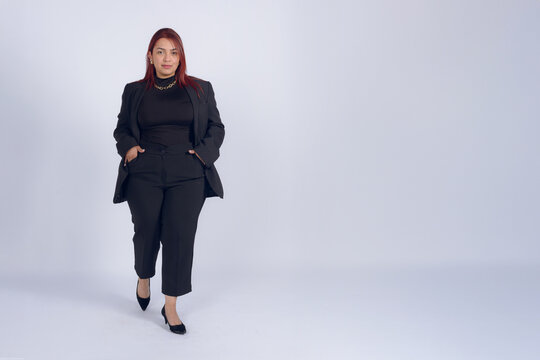 Full body portrait of businesswoman in black with hands in pockets