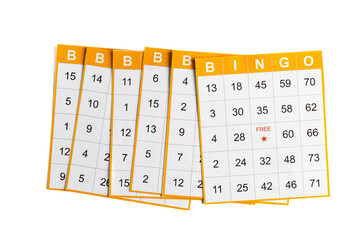 yellow and white paper bingo cards with a pencil on white background.