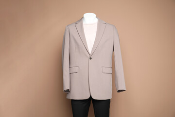 Male mannequin with stylish outfit on light brown background