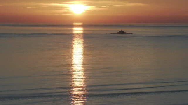 Aerial drone shot of the Forte do Bugio lighthouse, Tagus river, Atlantic Ocean and horizon at sunset from Lisbon, Portugal, Europe. Shot in ProRes 422 HQ Log