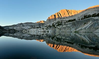 The morning sun on North Peak reflected in the still waters of Steelhead Lake in the Twenty Lakes...