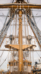 Obraz premium Full View of a Tall Ship's Mast with Rigging and Crossbars