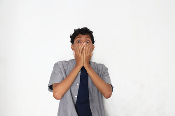 A man covering his mouth in surprise or shock.