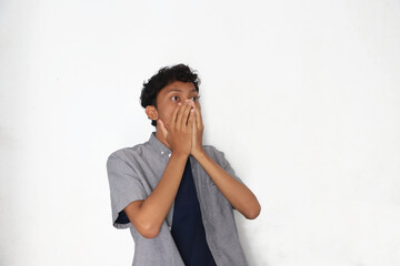A man covering his mouth in surprise or shock.