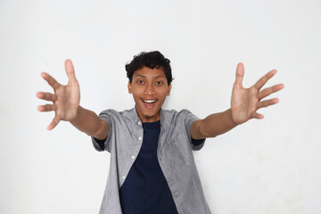 A smiling man with his arms in a hugging position.