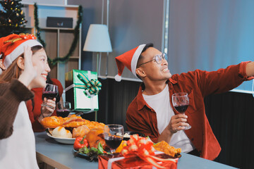 Group of young Asian man and women as friends having fun at a New Year's celebration, holding gift...