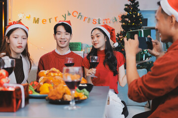 Group of young Asian man and women as friends having fun at a New Year's celebration, holding gift...