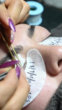 Detail of eyelash placement with small tweezers