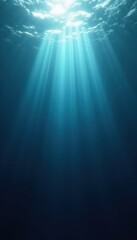 Obraz premium Mysterious deep blue ocean with light beams penetrating through the water surface