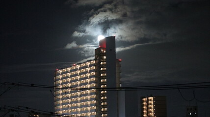 full moon full of clear night sky and beautiful towering buildings