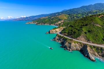 Fototapeta premium Scenic road winding along a coastal cliff, with the ocean on one side and mountains on the other, a popular travel route