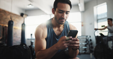 Fitness, gym and man with phone rest for social media, internet and online message. Athlete, health...