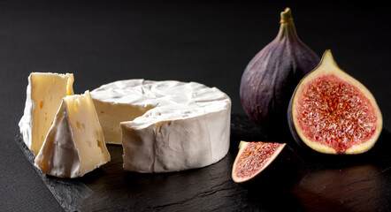 fresh cheese and figs on a black table