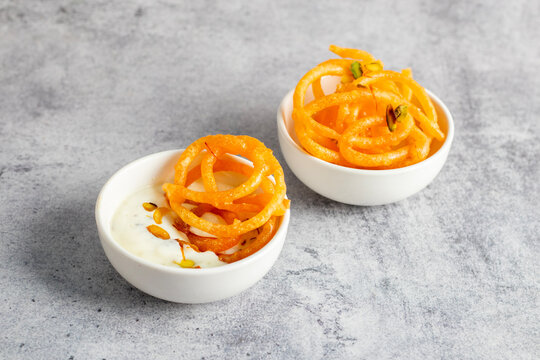 Jalebi, crispy and syrup-soaked, served warm with creamy, chilled rabdi for a deliciously sweet and rich combination.