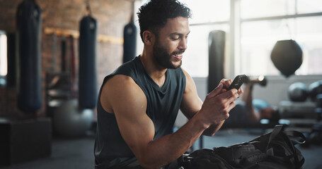Fitness, gym and man with phone on break for social media, internet and online message. Athlete,...