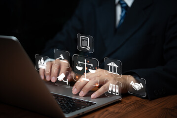 Hand holding holographic icons representing justice, law, and governance tools. Highlights legal...