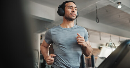 Man, headphones and workout on treadmill at gym for running, training and cardio exercise. Fitness,...