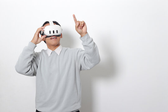 Portrait of Asian man using virtual reality VR device, experiencing immersive technology. Isolated image on white background