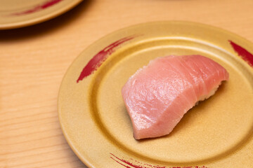 A close-up shot of Chutoro tuna sushi on golden plate. Traditional Japanese food.