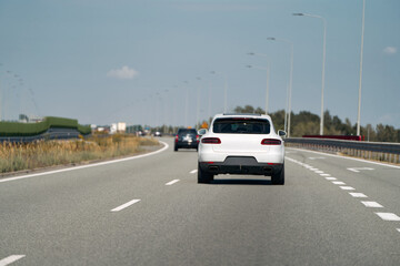 Rear view of white car on highway.