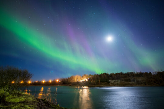 Hella Iceland on April 16, 2024. Aurora borealis northern lighs over the city by the river.