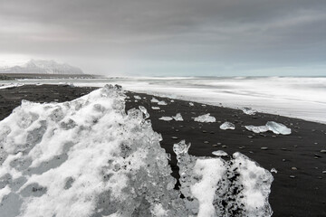 Iceberg at Diamond Beach Joekulsarlon. Blue chunk of ice on the black sand beach near the Glacier...
