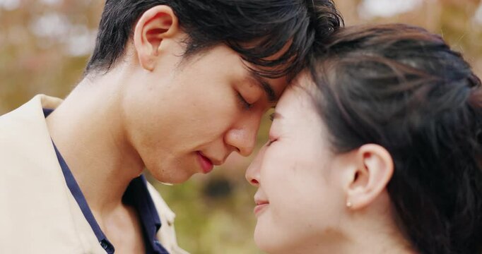 Japanese couple, forehead touch and happy in park or countryside for bonding, relationship and love. Woman, man and outdoor for romance, connection and commitment with eyes closed on valentines day
