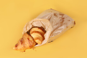 Bakery bag with croissants on a colored background