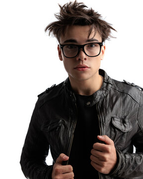 young punk guy in his 20s with glasses adjusting black leather jacket