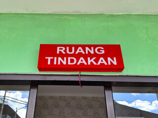 warning board with the words ruang tindakan in English action room. special room for emergency patients in a hospital