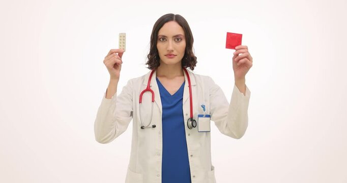 Brunette woman doctor shows oral contraceptives and condoms. Female gynecologist in medical uniform presents methods of contraception slow motion