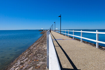 Obraz premium Walking along the seaside at Wynnum jetty and Manly, a beautiful sunny clear and blue sky day 